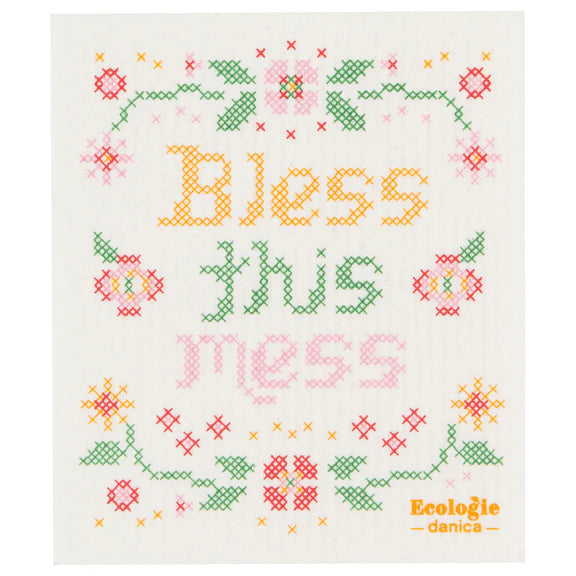 Reusable sponge cloth with a faux cross stitch sampler design that reads "Bless this Mess"