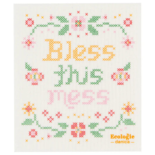 Reusable sponge cloth with a faux cross stitch sampler design that reads "Bless this Mess"